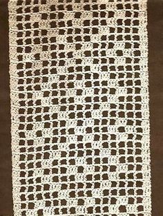 a white crocheted blanket sitting on top of a table