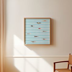 a wooden chair sitting in front of a wall mounted art piece