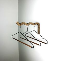 three wooden clothes hangers are hanging on the wall