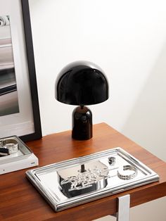 a desk with a lamp and pictures on the wall next to it in front of a framed photograph