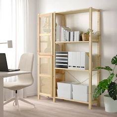 a white desk with a laptop computer on top of it next to a book shelf