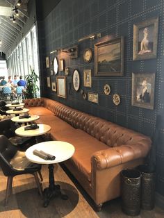 a restaurant with leather couches and pictures on the wall