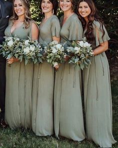 a group of people standing next to each other in front of trees and grass with flowers