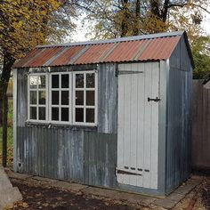 an old outhouse with a rusty tin roof