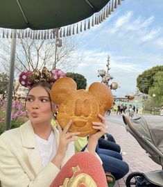 a woman holding up a mickey mouse bread