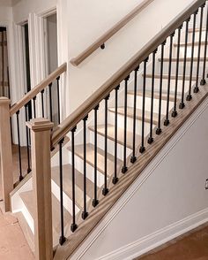 an empty room with white walls and wooden stairs