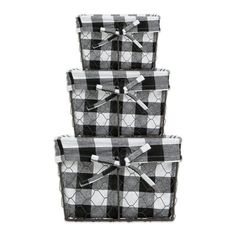 three black and white baskets stacked on top of each other, with bows in the middle