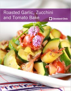 a salad with cucumbers, tomatoes and other veggies in a white bowl