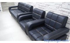 three black leather couches sitting next to each other in front of a brick wall