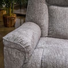 a grey recliner chair sitting next to a potted plant