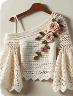 a white crocheted top with flowers on it