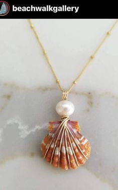 a necklace with a shell and pearl on it