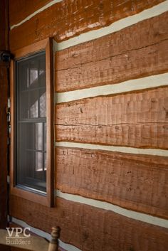 a window on the side of a wooden wall