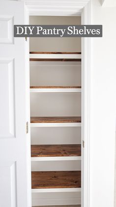 an empty closet with white shelves and wood flooring