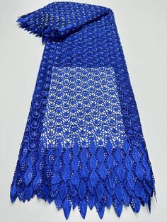 a blue and white scarf with fringes on the ends is laying on a table