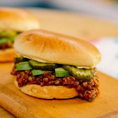 two sandwiches are sitting on a cutting board