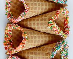 three ice cream cones with sprinkles and chocolate