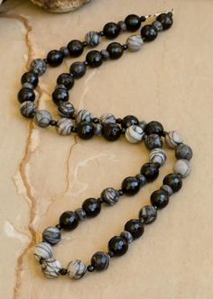 "Jackson" is a new addition to our evolution collection. Gray and black jasper and black onyx. Necklace available in 24" or 30" lengths. Coordinating bracelets and necklace sold separately. With every purchase, a donation is made to plant a tree through our partnership with One Tree Planted. Luxury Onyx Beaded Necklace, Luxury Black Necklaces With Natural Stones, Black Obsidian Necklace With 8mm Beads, Black Obsidian Necklace With 108 Beads, Black Necklace With Gemstone Beads For Healing, Black Necklace With Healing Gemstone Beads, Black Necklaces With Gemstone Beads For Healing, Black Gemstone Beads Necklace For Healing, Black Polished Beads Necklace For Meditation