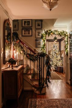 a staircase decorated for christmas with greenery and garland on the bannister railing