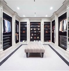 a large walk in closet with white walls and black flooring