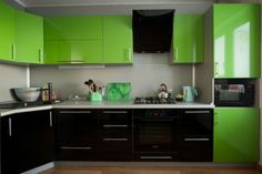 a kitchen with green cabinets and white counter tops