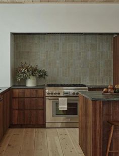 a kitchen with wooden cabinets and stainless steel stove top oven, counter tops, and bar stools