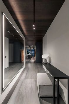 an empty hallway with a bench and mirror