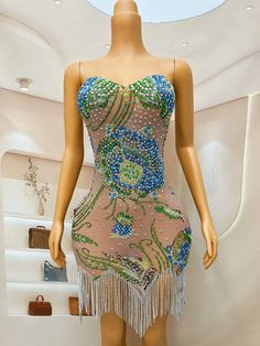 a mannequin wearing a dress with beads and fringes