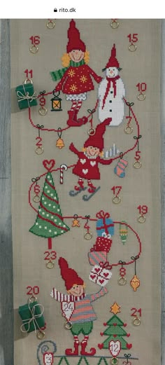 a cross stitch christmas scene with santa and elves