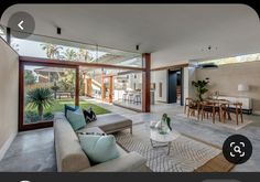 a living room filled with furniture next to a large glass doored window covered patio