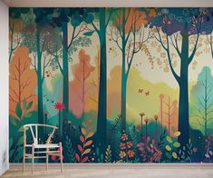 a chair sitting in front of a wall mural with trees and flowers on the side