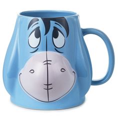 a blue coffee mug with a face painted on the front and sides, sitting in front of a white background