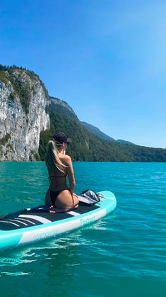 a woman sitting on top of a blue surfboard in the middle of the ocean