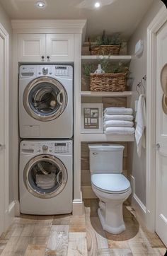 a washer and dryer in a bathroom with wooden floors, white cabinets and shelves