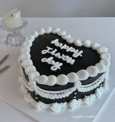 a black and white birthday cake sitting on top of a table next to a knife