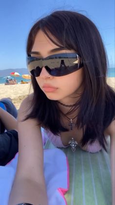 a young woman wearing sunglasses on the beach