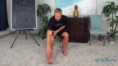 a man sitting on the floor in front of a chalkboard