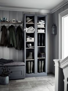 a closet with several coats and shoes on it in a room next to a window