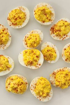 deviled eggs with mustard and seasoning are arranged in a circle on a white plate