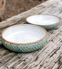 two blue and white bowls sitting on top of a wooden table next to each other