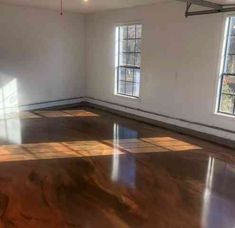 an empty room with large windows and hard wood flooring in the center is shown