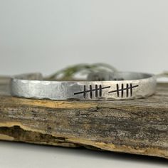 The perfect gift your wife on your 10th anniversary, this sweet cuff bracelet made with 10 tally marks to represent 10 years of marriage and handmade just for you. Your bracelet can have an inscription done on the inside to make it an even more special gift! Make that selection when adding it to your cart, and leave your message in the personalization box of through a message to me. This bracelet is 1/4 inch wide, and 6 inches in length. Looking for a 7 inch model for your husband? Click here: h Adjustable Cuff Bracelet For Anniversary, Handmade Adjustable Cuff Bracelet For Anniversary, 10 Year Anniversary Gift, Aluminum Bracelets, Tally Marks, Anniversary Gift For Wife, Pagan Jewelry, 10 Year Anniversary, Anniversary Gifts For Wife