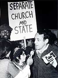 black and white photo of people holding signs in front of a building with the words separate church and state written on them