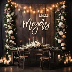 a table with candles and flowers on it in front of a sign that says mr and mrs