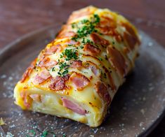 a piece of ham and cheese roll on a plate with parsley sprinkled around it