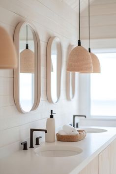 a bathroom with two sinks and three mirrors