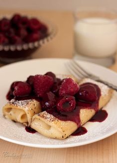 crepes with berries and powdered sugar on a plate