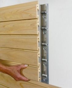 a man is holding onto the side of a wall with wood slats on it