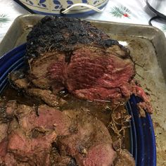 there is a roasting pan with meat on it and another dish in the background