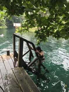 a person sitting on a wooden dock in the water